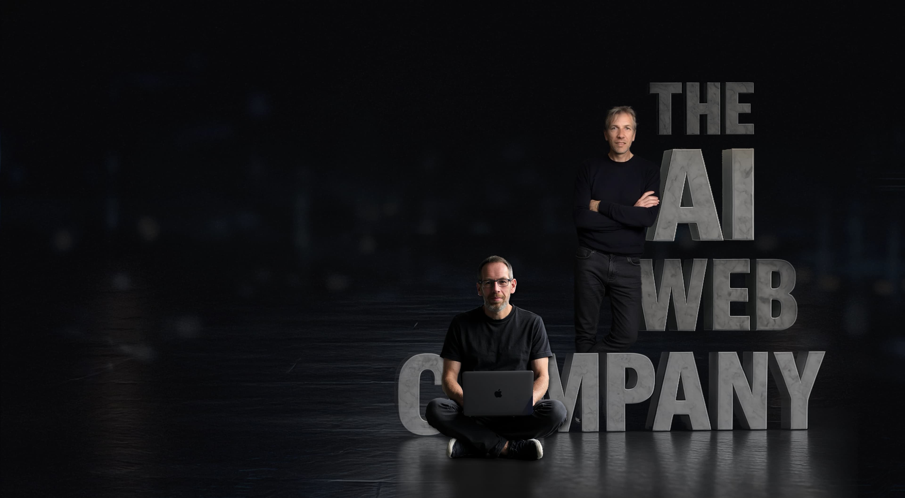 Neil and David, founders of The Ai Web Company, standing beside giant three-dimensional THE AI WEB COMPANY lettering